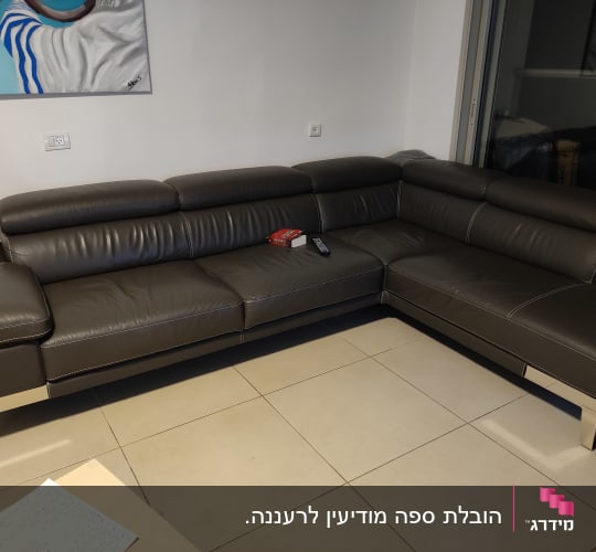 ספה פינתית חומה עם שלט וטישו על המושב